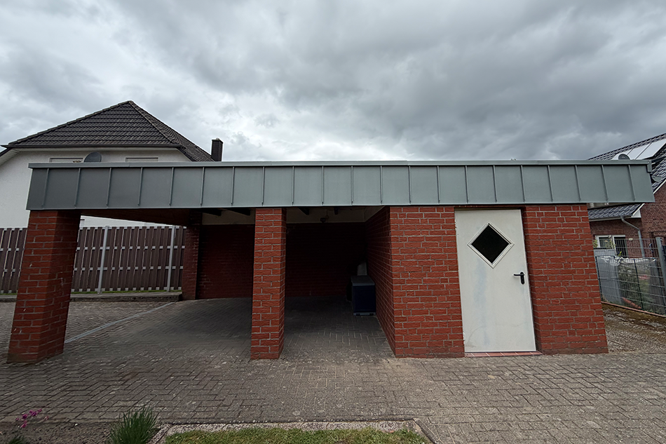 Fertig gebauter Carport mit Flachdach und Ziegeleindeckung an einem Wohnhaus. Carport-Bau und Dachdeckerarbeiten von Thomas Bauer aus Visselhövede